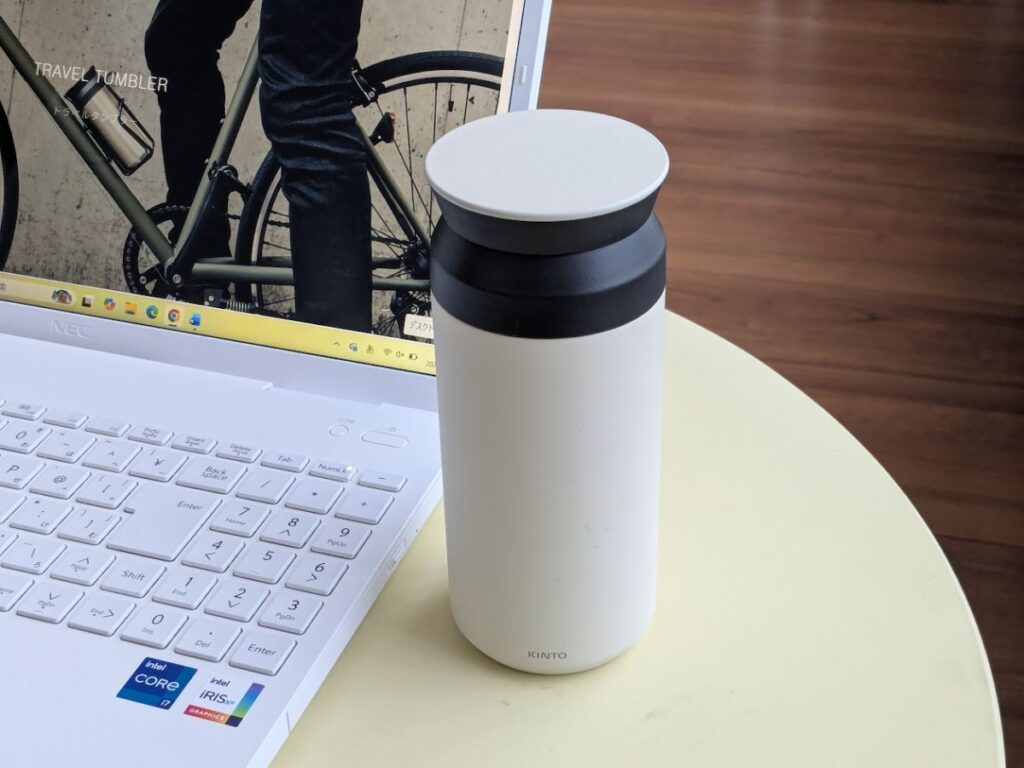 パソコンの横にKINTOトラベルタンブラーを置いている様子