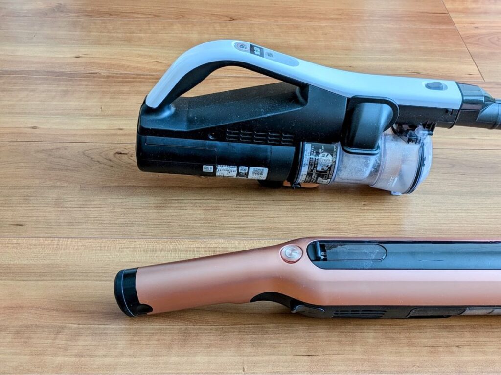 日立ラクかるスティックとシャーク掃除機を床に置いて並べた様子