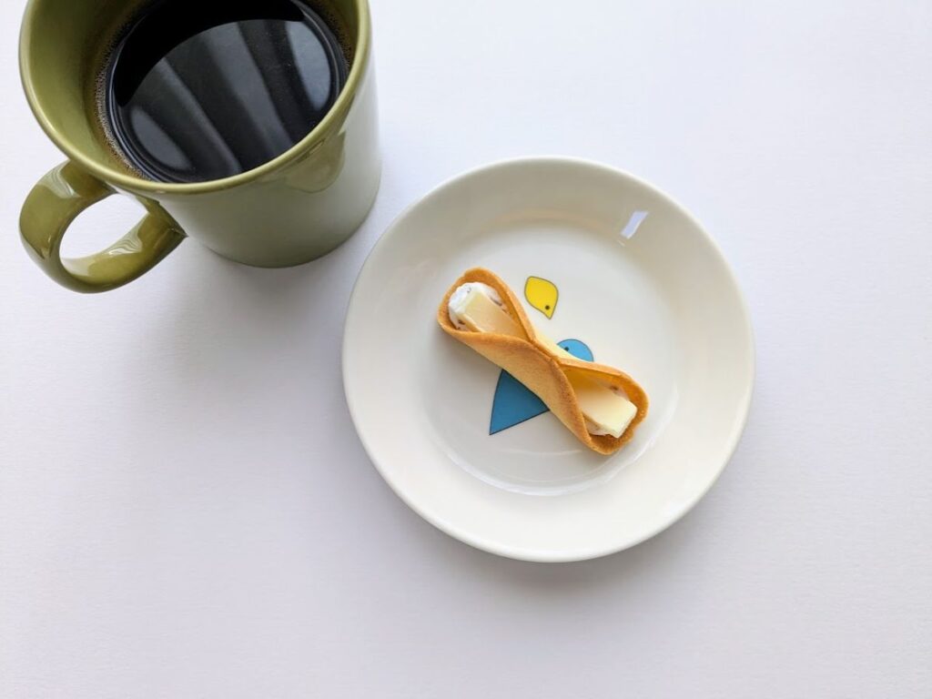 皿に乗せたニューヨークパーフェクトチーズの中身とコーヒー