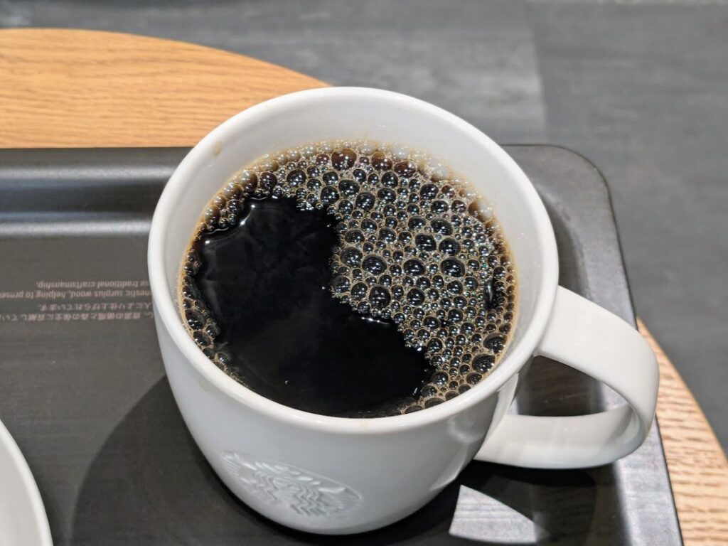 スターバックスのブリュードコーヒー（ブラック）を白いマグに注いだ写真。表面に細かな泡が浮いている