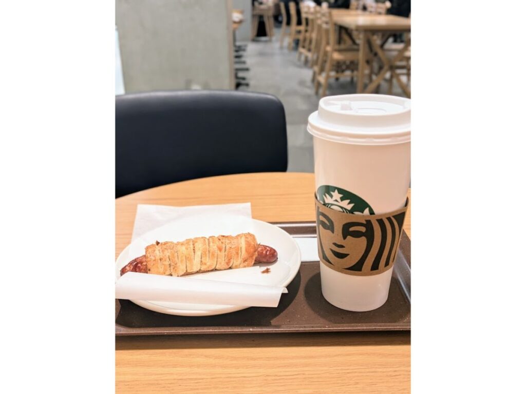 「スターバックスの店内で、ベンティサイズの紙カップとフードがトレーに載っている写真」