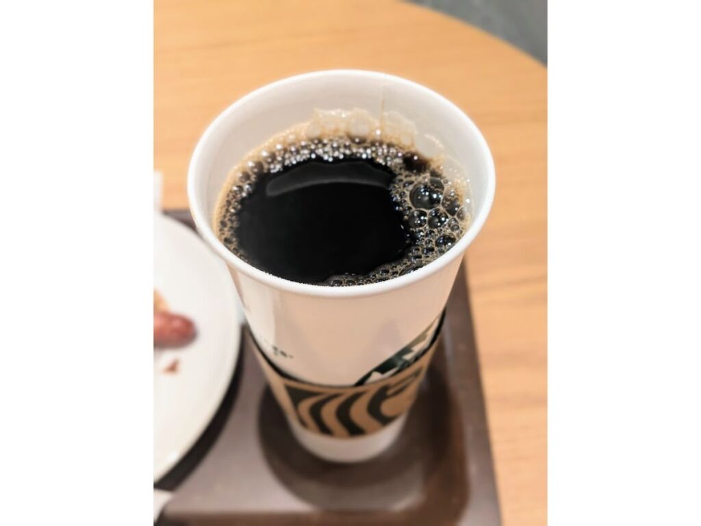 「スターバックスのベンティサイズのホットコーヒーを上から撮影した写真（店内）」