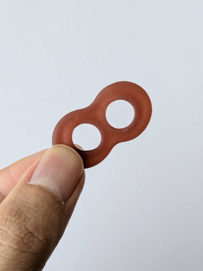 忍者めし鋼のグミを指で持っている画像。8の字の形が特徴的。